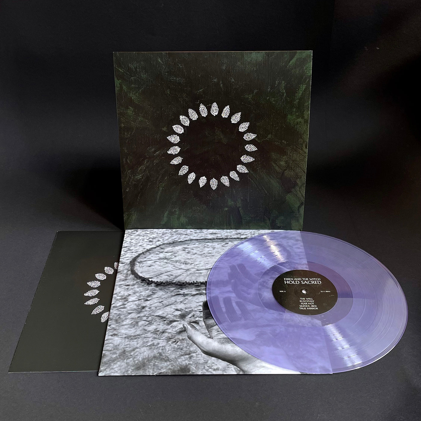 Limited edition amethyst colored vinyl LP record. The album cover is black with a white pine cone circle design.