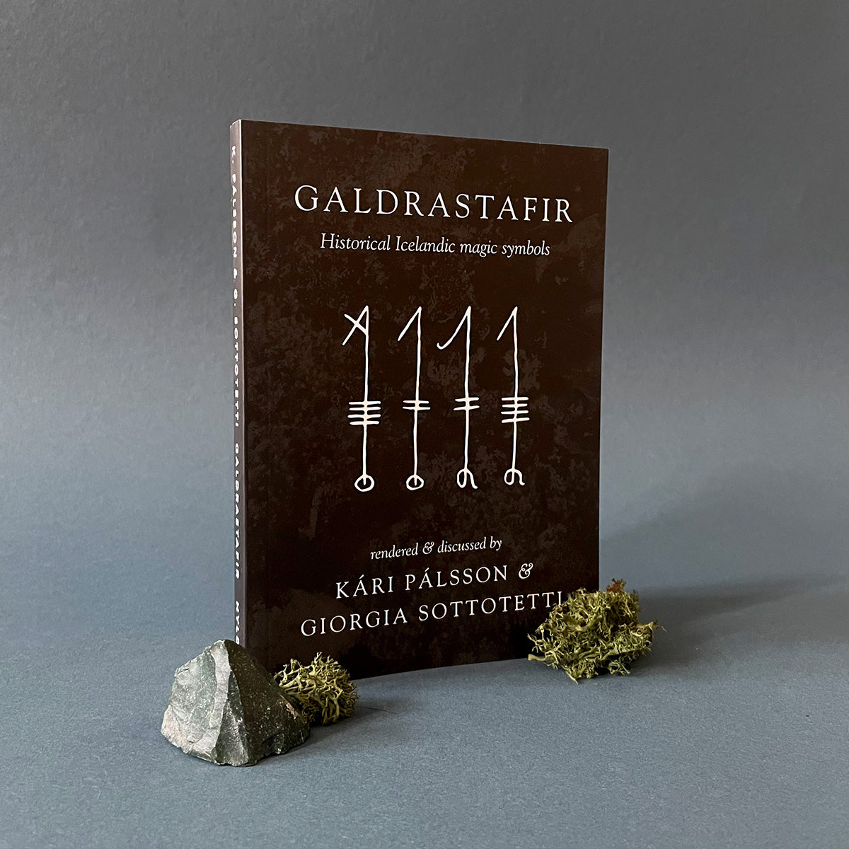 Book titled 'Galdrastafir' on a gray background with decorative elements.