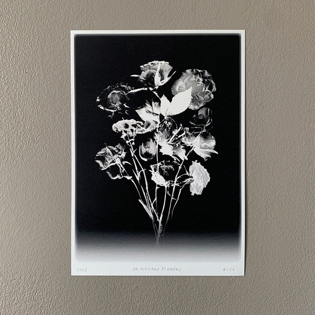 Black and white floral print on a textured wall.