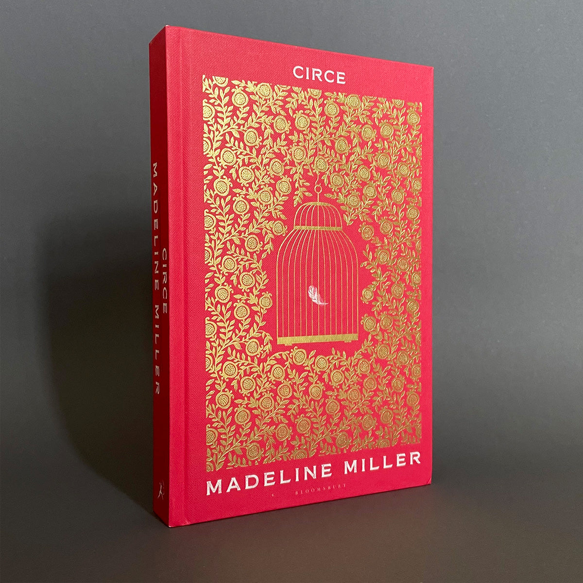 The image shows the cover of a book titled 'Circe' by Madeline Miller. The cover has a red background with a gold floral pattern and features an illustration of a birdcage in the center.