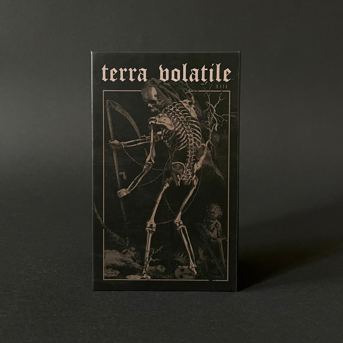 Terra Volatile tarot card deck with artwork depicting a skeleton against a dark background.