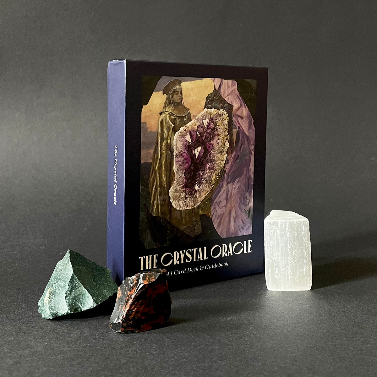 The Crystal Oracle card deck and guidebook with crystals on a dark background