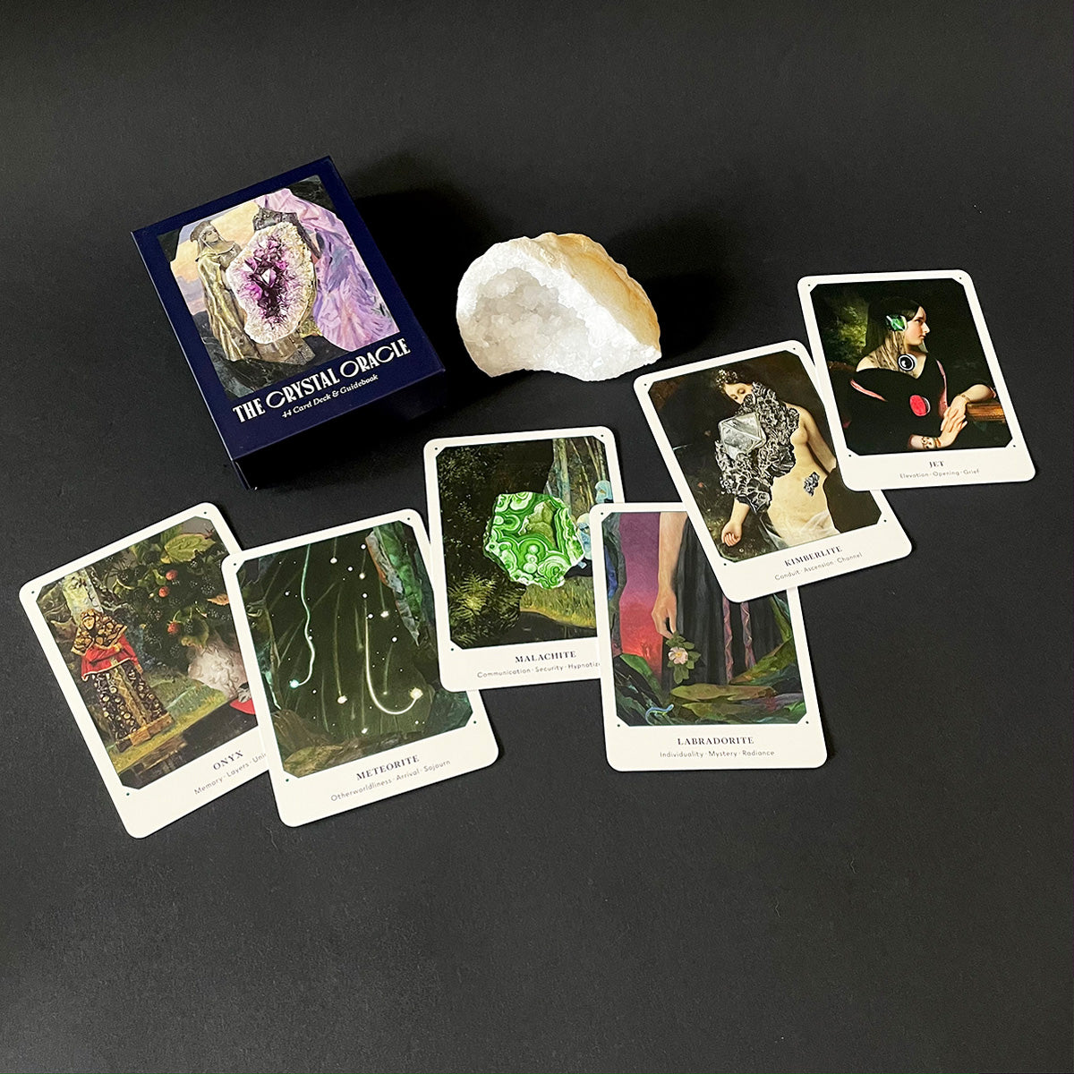 Set of oracle cards with a crystal and box on a dark surface