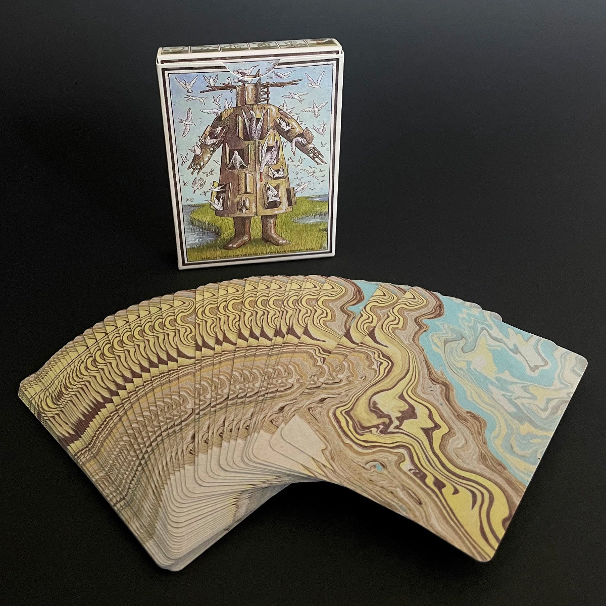 A spread of playing cards from The Drowning World deck, showing a variety of illustrated cards backs with natural and abstract patterns.