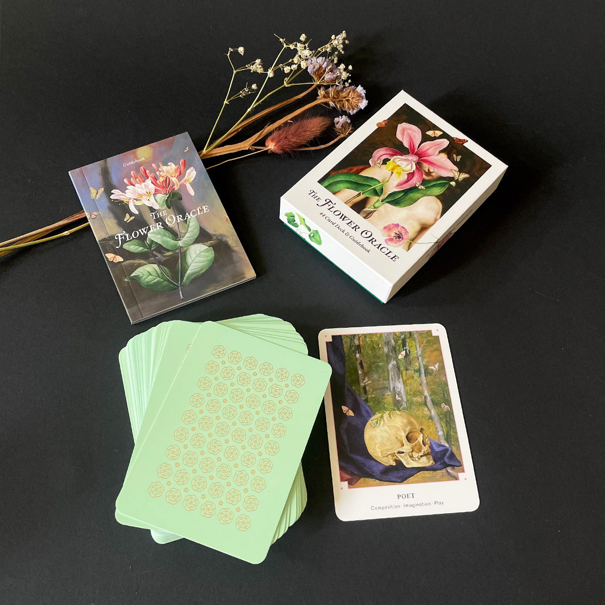 Flower Oracle cards with dried flowers on a dark surface