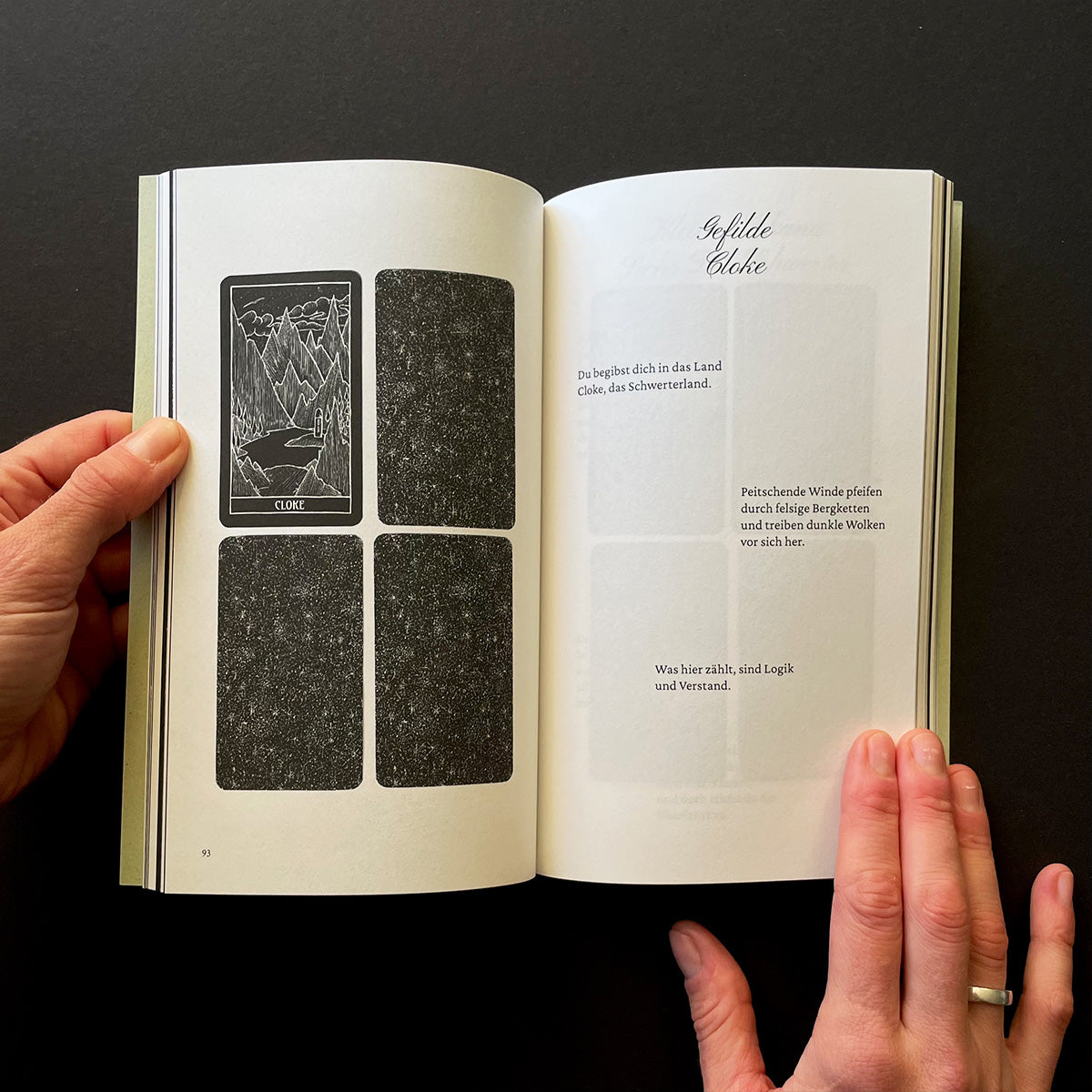 Open book with tarot card illustrations and text on a black background